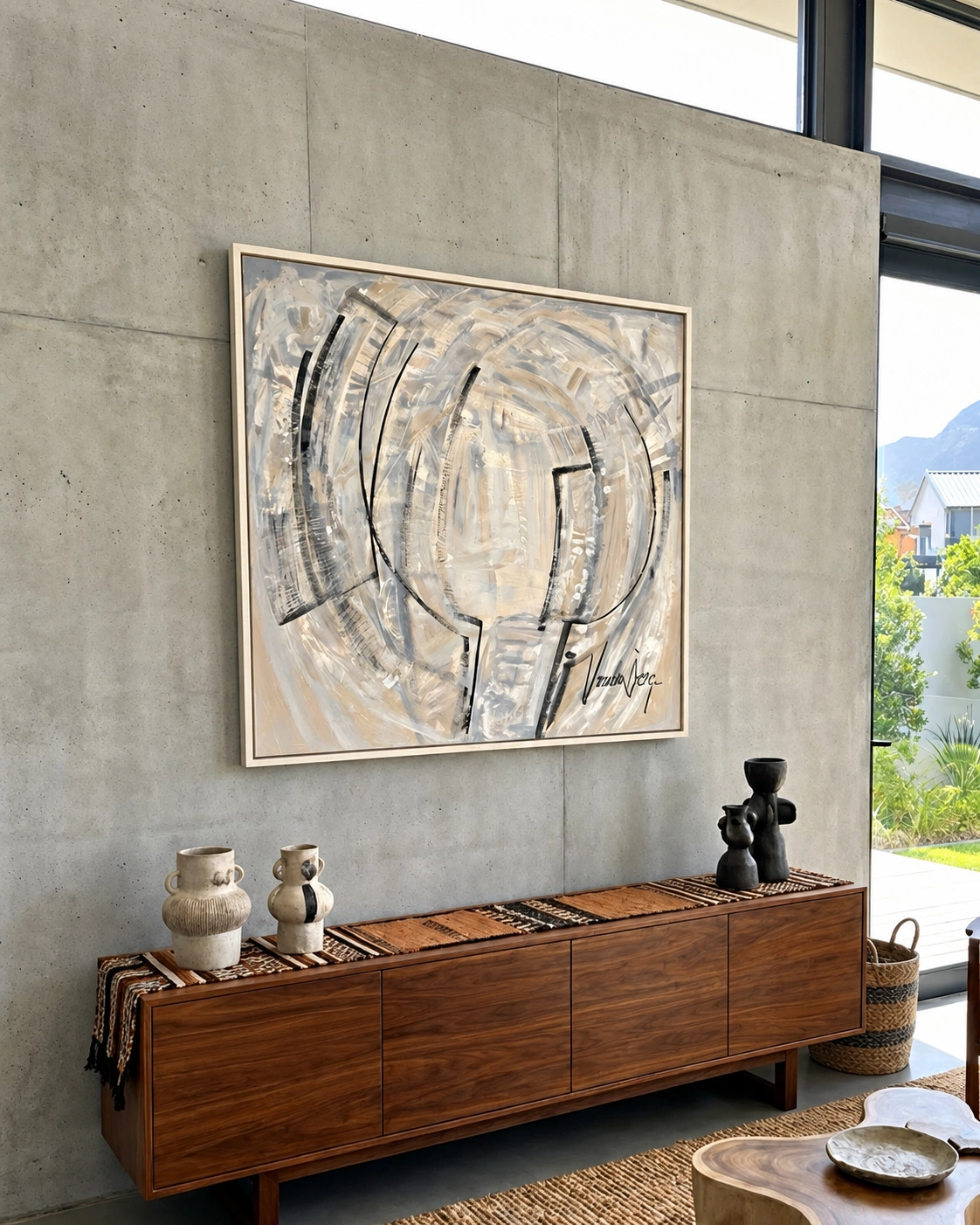 A pale ivory and grey abstract painting on a concrete wall above a timber sideboard